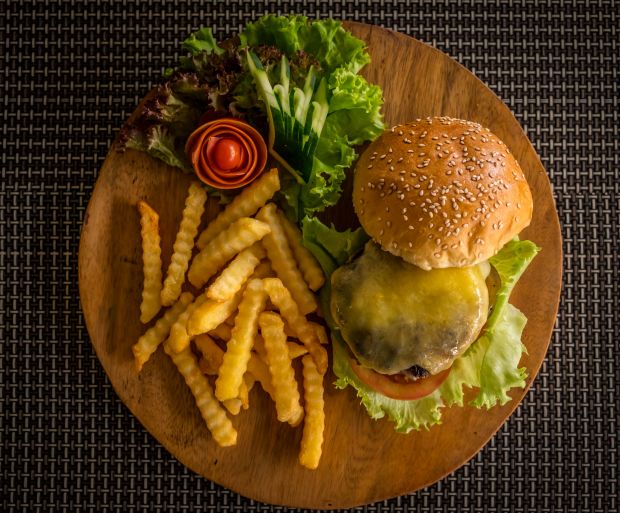 Cheese burger with fries on a wooden board
